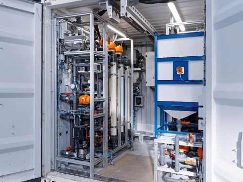 A look inside the container shows filter cartridges and piping