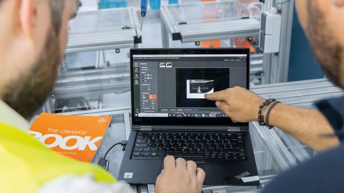 两名员工查看显示摄像头传感器图像的笔记本电脑。